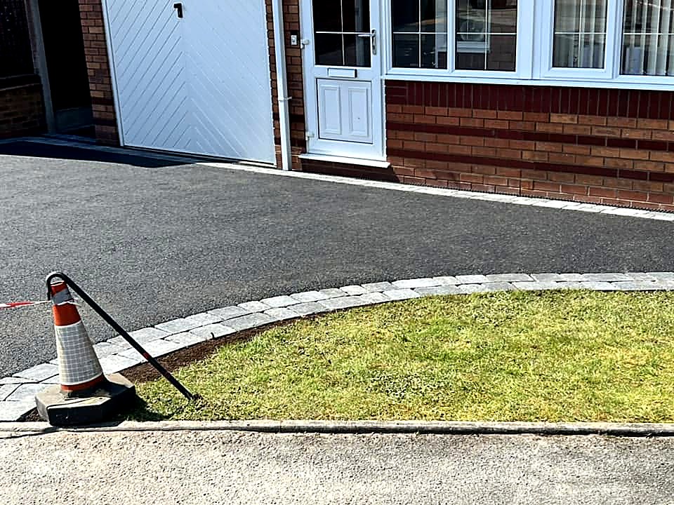 Finished tarmac driveway with kerbed lawn edge